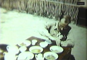Frame from a film made by SACO, Steinberg eating with chopsticks at SACO headquarters in Happy Valley, China, 1943