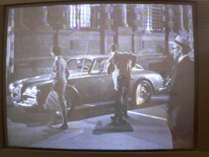 Frame from Alberto Lattuada’s film Scuola elementare (Elementary School), with Steinberg, at right, as an extra in the Galleria of Milan.