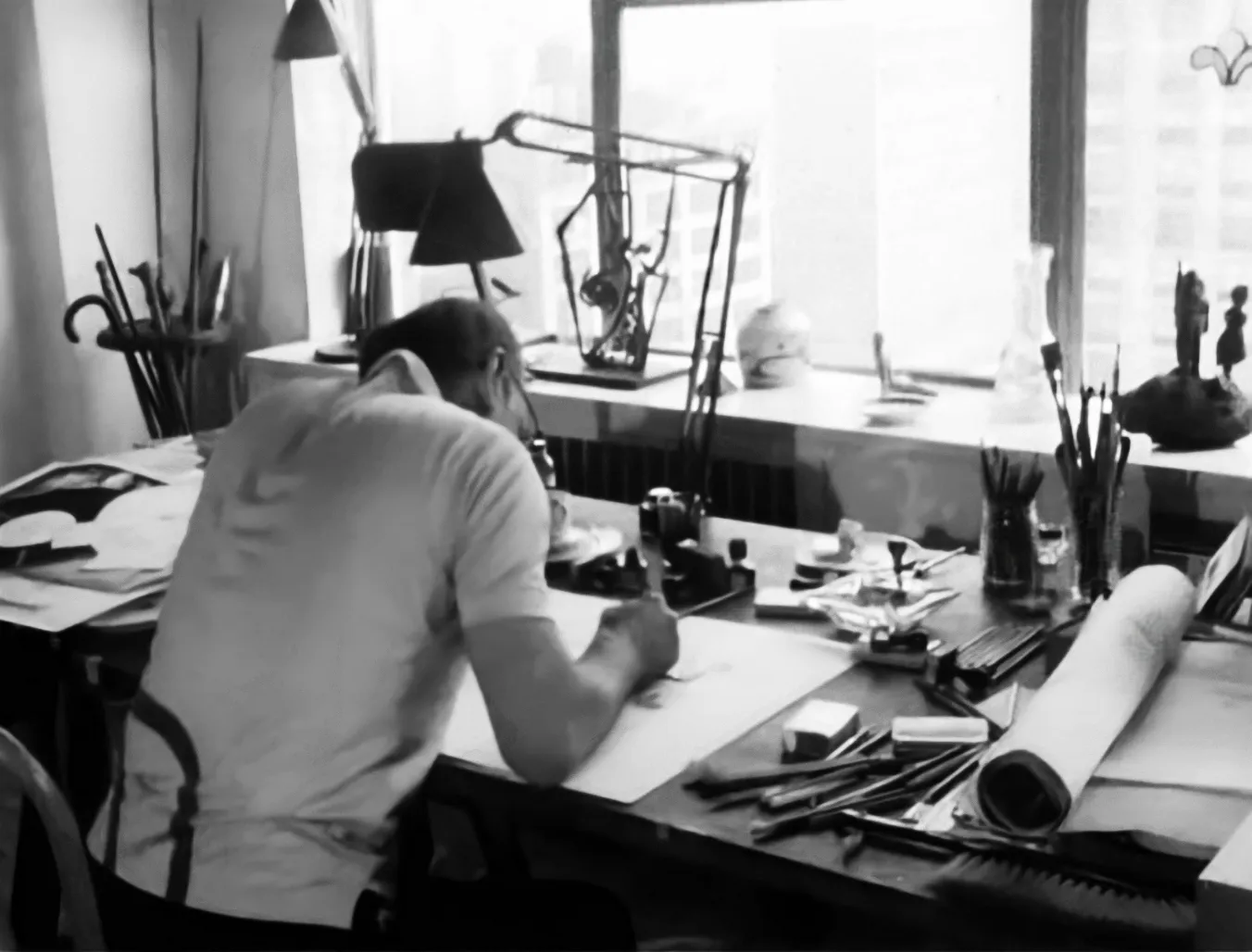 Saul Steinberg working at his desk.